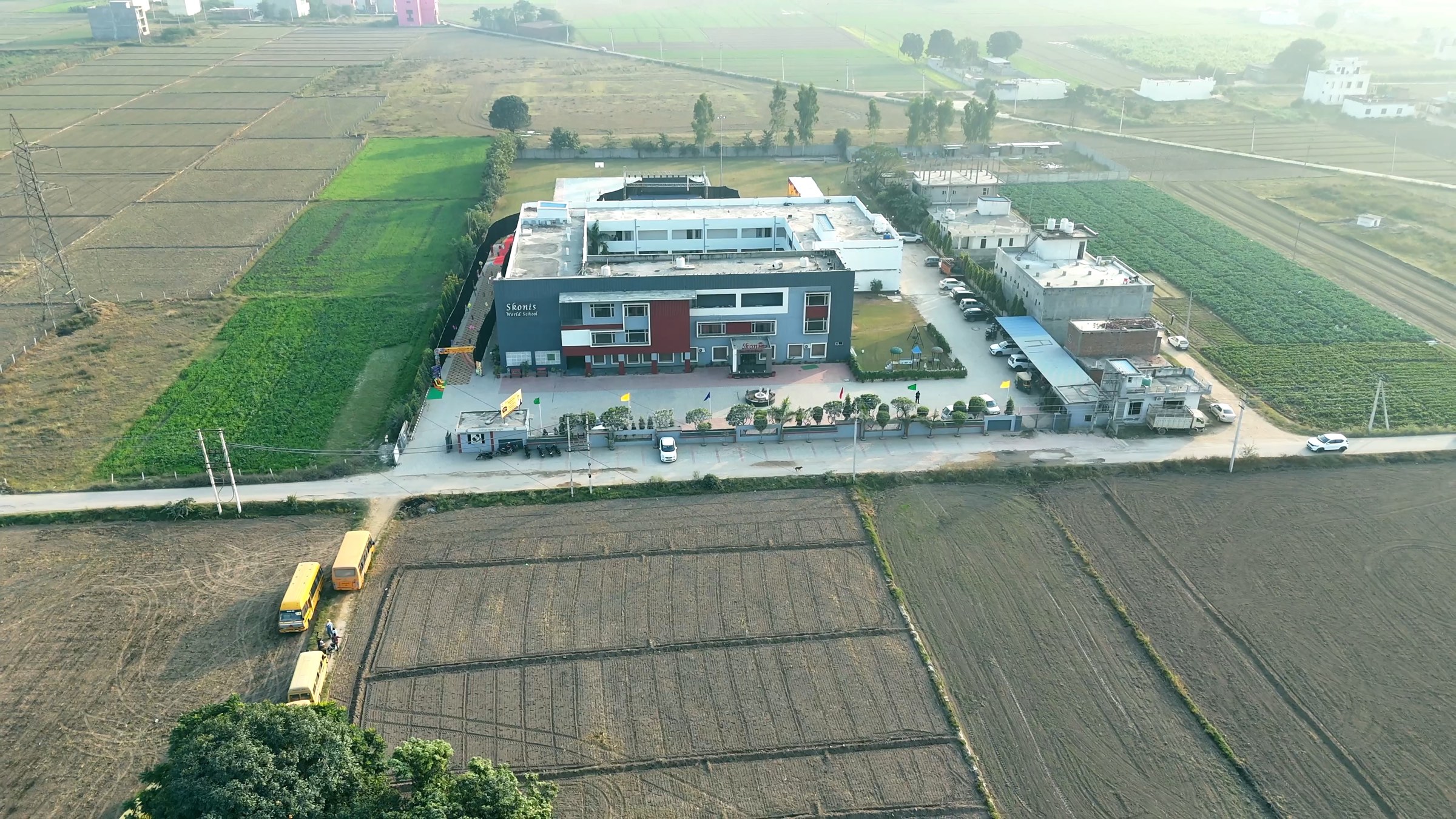 Aerial view of the Skonis World School campus among green fields